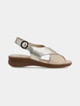 Sandalia de cuero con diseño de tiras cruzadas en combinación de tonos metalizado dorado y beige, con cierre de hebilla lateral y suela de goma tipo corcho.