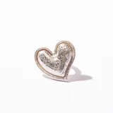Anillo plateado con forma de corazón con textura irregular.