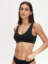 Top deportivo negro sin costuras, con breteles anchos y escote redondo.
