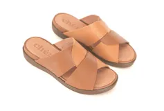 Sandalias de cuero color caramelo, con tiras cruzadas en el empeine, plataforma baja y suela de poliuretano flexible.