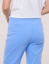 Pantalón capri estilo sastrero de tiro alto, color celeste, con cintura ancha elastizada sin cierres, bolsillos funcionales en el frente y bolsillos simulados en la parte posterior.