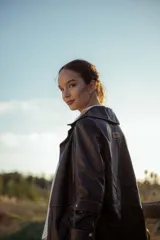 Chaqueta de cuero ovino italiano color negro, con cuello clásico, cierre frontal con botones a presión, bolsillos laterales con solapa y costuras en contraste color naranja.