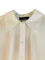 Camisa blanca de popelina con manga larga, cierre con botones delanteros y bordado en contraste en la espalda con la frase 'Love yourself'.