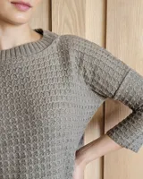 Sweater de punto color verde claro con textura tipo waffle, cuello redondo y mangas 3/4.