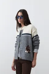 Cardigan de tejido jacquard en color azul marino y blanco, con diseño de conejitos en los laterales, cierre frontal con botones y cuello redondo.