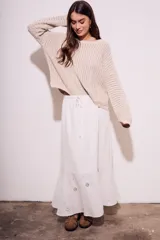 Falda larga blanca de viscosa y lino, con cintura elastizada y cordón ajustable. Presenta bordado calado con motivos florales en el ruedo.