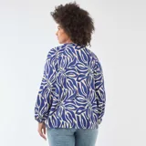 Blusa de manga larga con estampado abstracto en tonos azul y beige, cuello en pico y diseño holgado con puños elásticos.