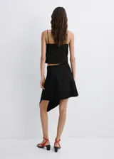 Falda midi negra de tiro medio, con diseño evasé y corte asimétrico.
