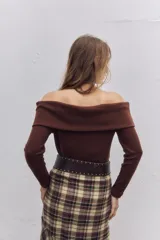 Buzo de punto color chocolate, con diseño de hombros descubiertos y cuello estilo solapa, de manga larga y ajuste al cuerpo.