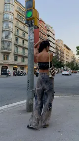 Pantalón cargo oversize de jean con múltiples bolsillos funcionales y detalles metálicos en bronce.