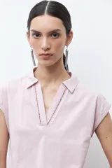 Remera azul marino de manga corta con cuello polo y escote en V con cierre.