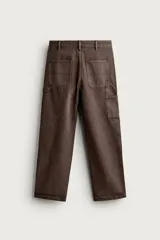 Pantalón jeans relaxed fit de color marrón con efecto lavado, de corte recto y estilo carpintero. Cuenta con bolsillos laterales, bolsillos traseros, bolsillos aplicados y tira multifunción en la pierna. Cierre frontal con cremallera y botón metálico.