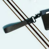 Llavero de muñeca con cinta de tela negra y gancho metálico negro. Detalle en cuero sintético negro con logo grabado.