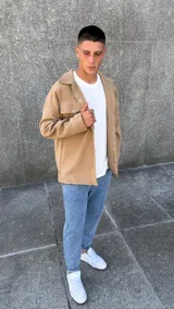 Chaqueta tipo sobrecamisa de paño en color camel, con cuello camisero, cierre frontal con botones metálicos a presión y bolsillos frontales con solapa.