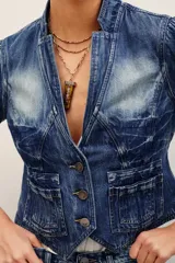 Saco de denim azul con efecto deslavado, corte entallado, cuello mao, mangas largas y cierre frontal con botones metálicos. Cuenta con bolsillos frontales appliquéd y un diseño de costuras estructuradas con dobladillo en punta.