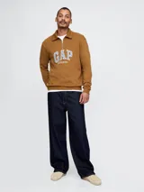 Buzo de algodón con medio cierre frontal y cuello tipo polo. Presenta el logo de la marca Gap bordado en el pecho en tonos azules.