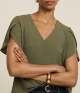 Blusa color beige de poliéster con efecto arrugado (airflow), escote en pico y mangas cortas tulipán (cruzadas).