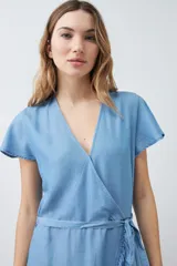 Vestido corto azul claro de lyocell, con corte cruzado, escote en V, mangas cortas con volados y lazo en la cintura.