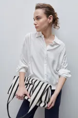 Camisa de viscosa color celeste, de calce amplio y caída fluida, con cuello clásico, cierre frontal de botones y detalles calados en mangas y delantero.