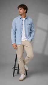 Camisa de jean de manga larga con cuello italiano, cierre frontal con botones y bolsillo en el pecho con detalle bordado.