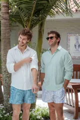 Short de baño celeste con estampado de hojas de palmera en blanco.