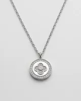 Collar de acero con dije redondo que presenta un diseño interior de trébol y detalles de circonias.
