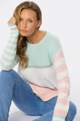 Sweater tejido fino con rayas horizontales en tonos pastel: celeste, gris, blanco y rosa. De corte clásico y cuello redondo.