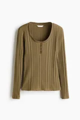 Top de manga larga en punto acanalado de algodón con diseño pointelle, escote en U con ribete festoneado y tapeta con botones frontales.
