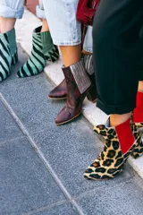 Botín de cuero con estampado de piel de serpiente en tonos marrón y rojo, con elásticos laterales plateados y tacón cuadrado.