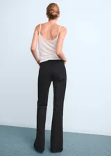 Jeans tiro alto de corte flare color negro, con cinco bolsillos, trabillas para cinturón y cierre frontal con botón y cremallera.