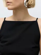 Top negro sin mangas con escote barco y tirantes finos.