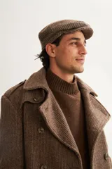 Boina con visera de lana fina uruguaya natural, sin teñir, con diseño de tejido texturizado en tonos beige y marrón.