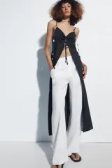 Top largo confeccionado en lino, color negro, con tirantes finos, escote en V con encaje y detalle de frunces y lazada frontal.