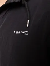 Campera de nylon con capucha, cierre frontal y forro de red. Presenta un diseño minimalista en color beige con detalles en negro.