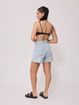 Top de bikini deportivo color negro, con escote redondo y breteles finos ajustables. Presenta el logo de la marca estampado en blanco en la parte inferior izquierda.