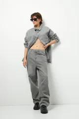 Pantalón de jean azul claro, de corte oversized y tiro bajo, con bolsillos traseros grandes.