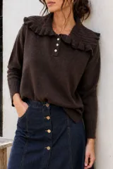 Sweater de algodón color marrón, con diseño de tejido de punto, cuello tipo babero con volados y cierre frontal parcial con tres botones blancos.