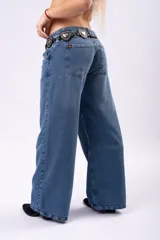 Jean de corte wide leg y tiro bajo, confeccionado en denim rígido de color azul clásico. Presenta un diseño de pierna ancha y recta, con costuras reforzadas y cierre frontal con botón.