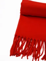 Pashmina de textura suave y acabado liso, con detalle de flecos en los extremos.