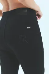 Pantalón jean negro de tiro medio alto y corte oxford con botamanga ancha al corte.