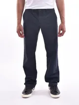 Pantalón de vestir azul oscuro, de corte recto, con bolsillos laterales y traseros. Se ajusta a la cintura con cinturón de cuero marrón.
