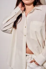 Camisa oversize de lino y viscosa color celeste, con cuello clásico, cierre frontal con botones y mangas largas.