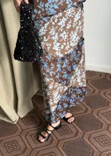 Falda recta de diseño versátil con estampado floral en tonos marrón y celeste, con detalle de botones a lo largo.