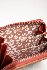 Billetera con cierre de cremallera y estampado animal print de leopardo.