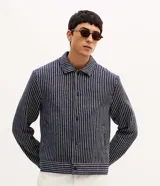 Campera masculina de corte recto con textura jacquard a rayas verticales en tonos azul marino y blanco. Presenta cuello inglés, cierre frontal con botones y manga larga.