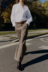 Camisa de corte amplio y estilo oversize, confeccionada en tejido tipo Oxford. Presenta cuello solapa con botones, cierre frontal abotonado, mangas largas con puños estructurados y bajo asimétrico.