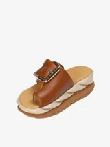 Sandalia marrón con hebilla metálica y aro para el dedo.