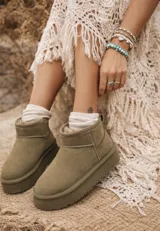 Pantubota de caña baja en color verde oliva, con plataforma plana y forro interior de piel sintética. Diseño minimalista con costuras reforzadas.