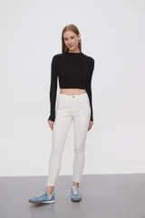 Pantalon de jean negro, corte skinny y tiro medio, con cierre frontal y bolsillos laterales.