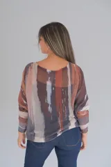 Sweater de tejido de punto fino con diseño abstracto en tonos tierra y detalles metalizados dorados, de corte holgado y manga larga.